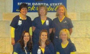 The nurses of the New Ulm Medical Center/Allina Health, show off their new scrubs and their school colors of yellow and blue.  Pictured from left to right in the front row is Tracy (Clement) Berg â€™02, Amanda (Rasmussen) Vetter â€™09, Sara (Lindquist) Kanuch â€™06. Back row left to right Sharie (Jundt) Novak â€™83, Clarice (Mudder) Rasmussen â€™85, and Tammy (Lupke) Palm â€™85.