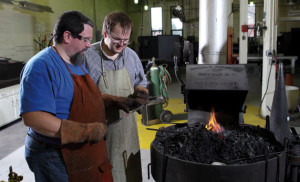 Engineering instructor Jason Prout, left, examines the blacksmithing work of Guzinski.