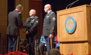  Sgt. Richard Bogue, center, shakes hands with Col. Stan Carrigan after receiving his Purple Heart Medal at the ceremony in the Performing Arts Center at South Dakota State University. Bogue, of White, is a May 2014 graduate of SDSU. At right is Staff Sgt. Walter Scott. 