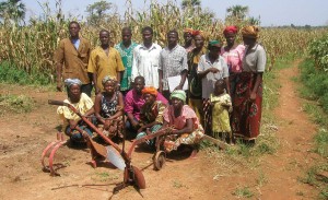 A large group of people stand in front of a field in Burkina Faso.