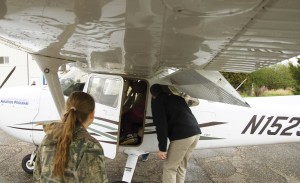 Two students look at the cockpit of an airplane.