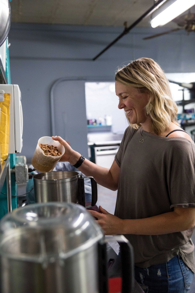 Kari Doyle pours nuts into a pot to make nut butter.