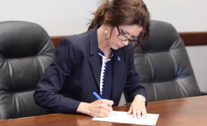 Governor Kristi Noem signs a document.