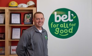 A man stands if front of a wall with the Bel Brands logo.