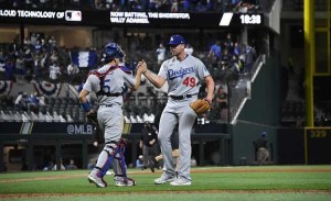 A pitcher and catcher share a high five.