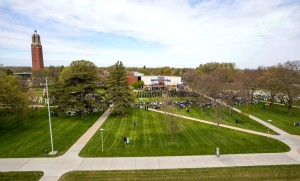 College green filled with graduates during commencement ceremony.