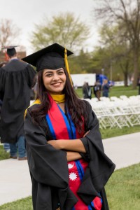 A female graduate poses on the college green following the graduation ceremony.