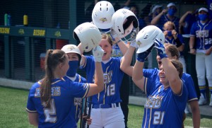 Softball players hit helmets together in celebration.