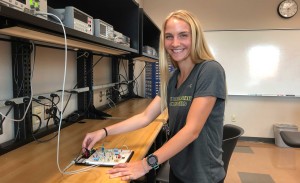 A female engineering intern works with a lot of colorful wires.