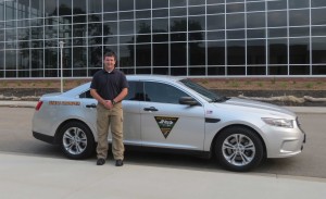 A man stands beside a Highway Patrol car