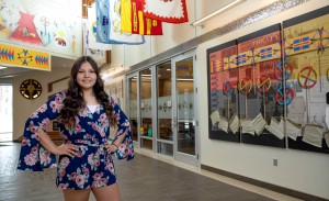 A female college student stands with hands on her hips in the American Indian Student Center.