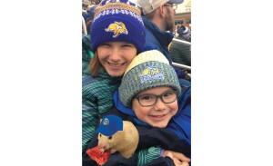Two kids hold a hamster wearing an SDSU hat.