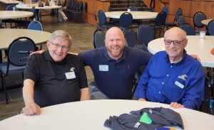 Three alums smile for a photo.