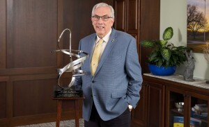 President Barry Dunn poses behind a metal award.