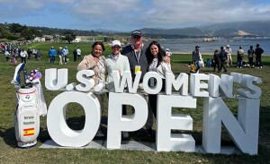 A golfer stands with her family behind a large U.S. Women's Open sign.